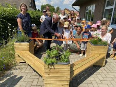 Im Einklang mit der Natur: Der Förderverein hat dem städtischen Familienzentrum eine Kombi aus Bänken und Pflanzkübeln für die Naturerlebnispädagogik im Werte von über 2000 Euro geschenkt. Hier die offizielle Einweihung mit dem Bürgermeister und den Vereinsvorsitzenden, der Leitung sowie ganz vielen Kindern beim Durschneiden des Bandes. Foto: (cp)